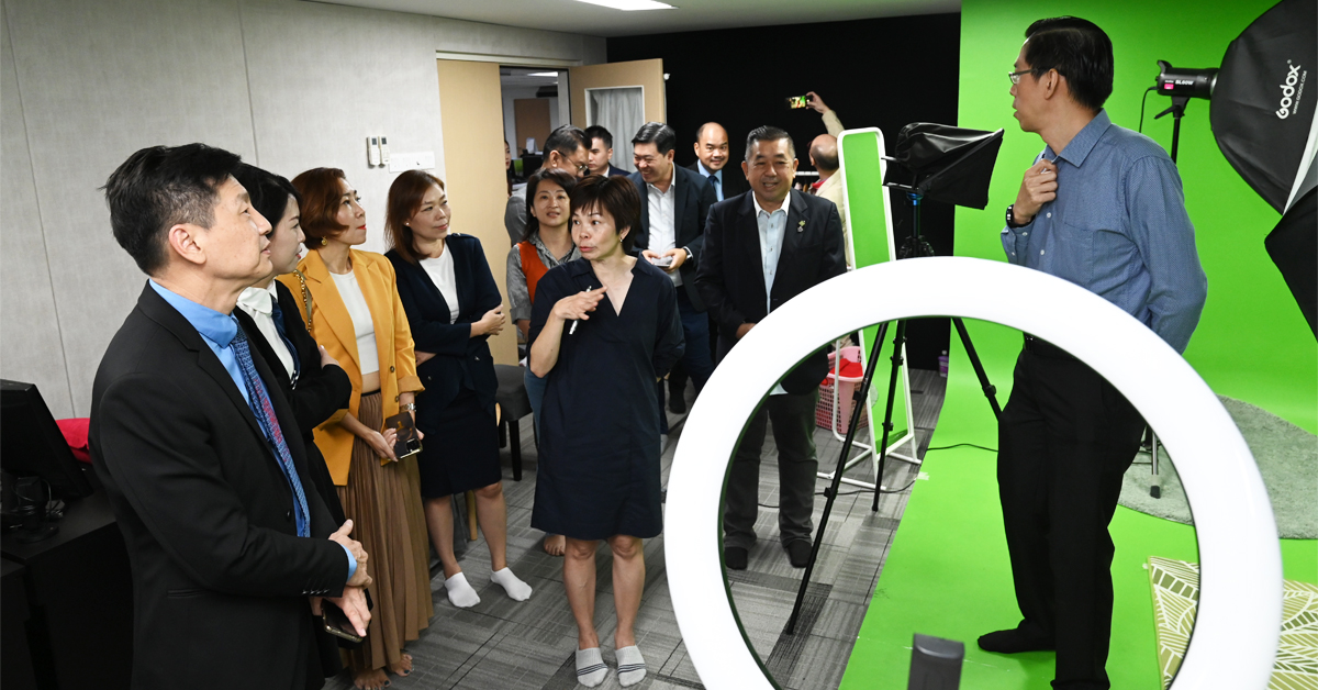 林明标(右)带领大马讲师协会代表团参观《中国报》的摄影棚。