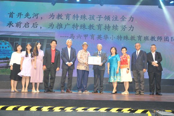 吴采凤（右4起）和林金宝代表马六甲育英华小特殊教育班教师团队，从李金友手中接过沈慕羽教师奖奖状。