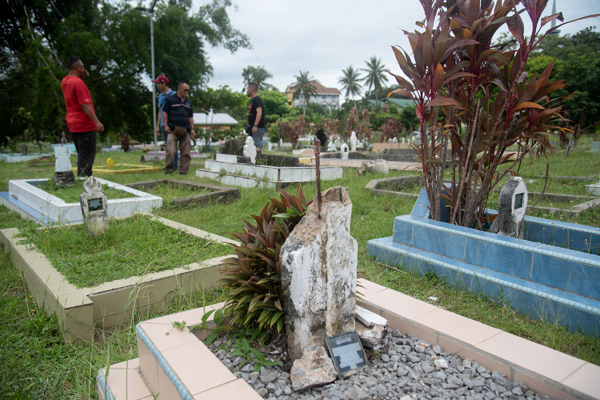 墓碑被嫌遭拦腰斩断，上半部分仅余内部钢条裸露在外。马新社