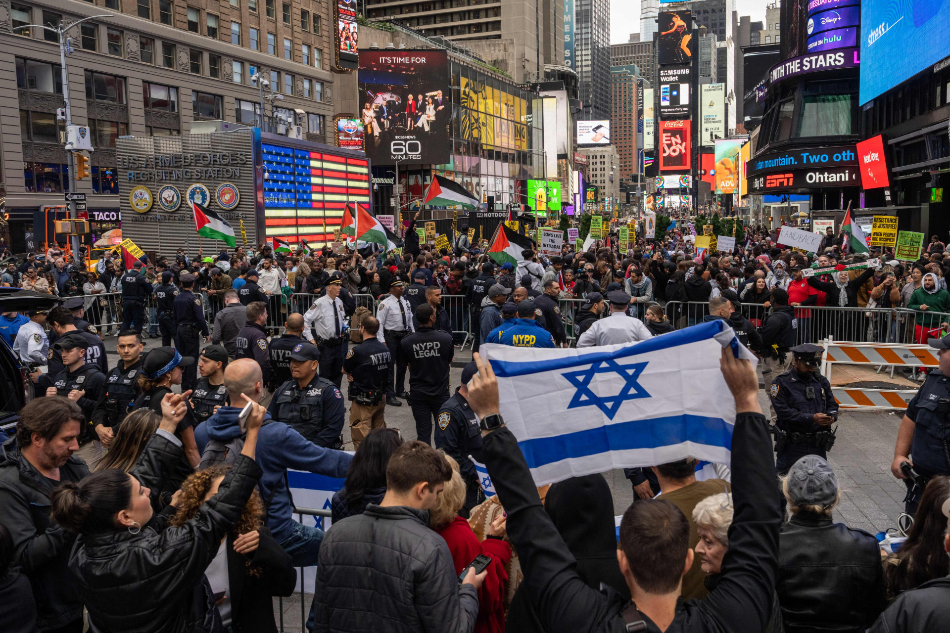 支持以色列的民众张开以色列国旗，向对面的巴勒斯坦支持者喊话。（法新社）