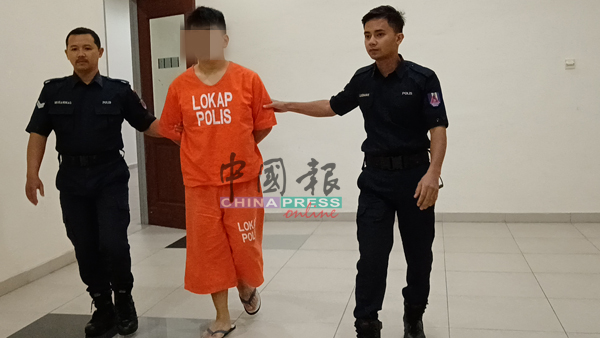 被告郑金明（中）被庭警带离法庭后，将被带至新山柏迈医院接受精神检查。
