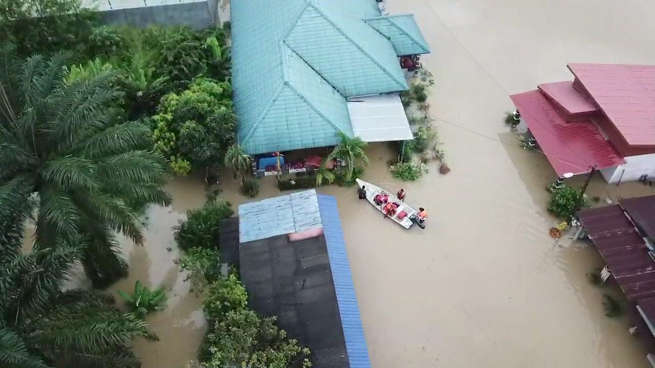 该甘榜被水灾淹没过半，消拯员乘船到其中一处住家，救出受困的一家7口。