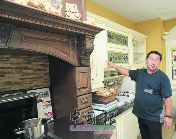 王建豐在介紹木製櫥櫃的線板雕花設計。