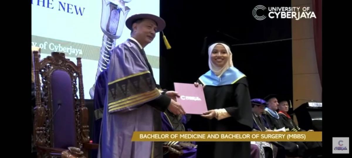 诺希山（左）颁发毕业证书给毕业生。