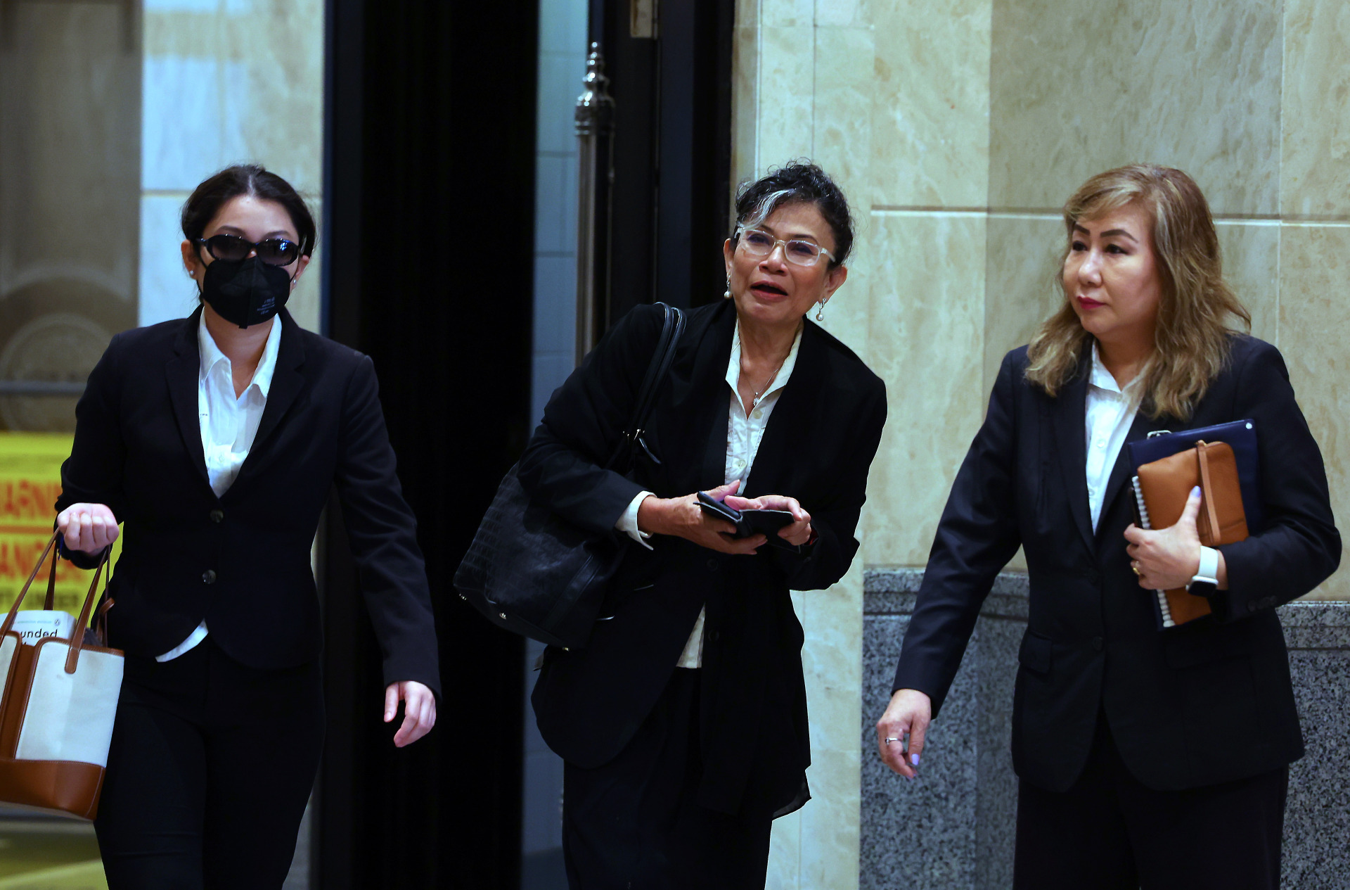 东姑雅丝敏（左起）和聂依琳祖丽娜周一（20日）在休庭后，与律师公会主席谢依琳一起步出法院。