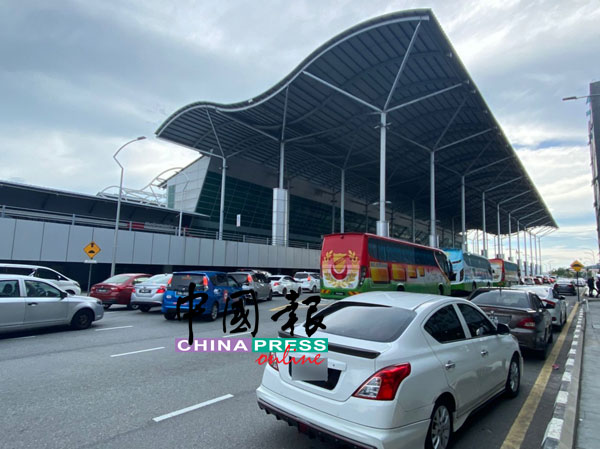 槟城国际机场外，有不少旅游巴士及车子，在等待载送抵槟乘客。