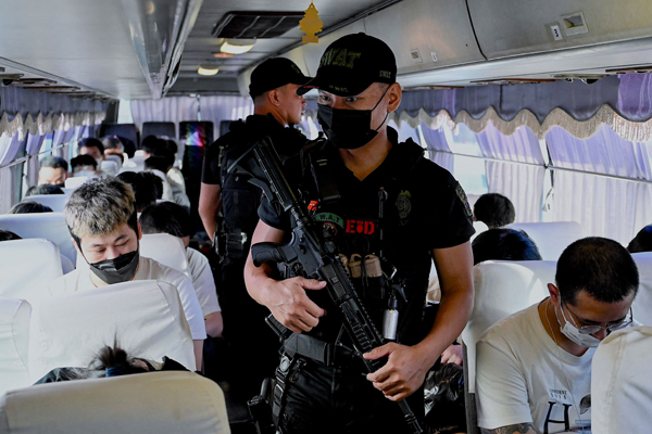 当局安排巴士将遭驱逐的中国人载往机场，警察在车上严密驻守。（法新社）