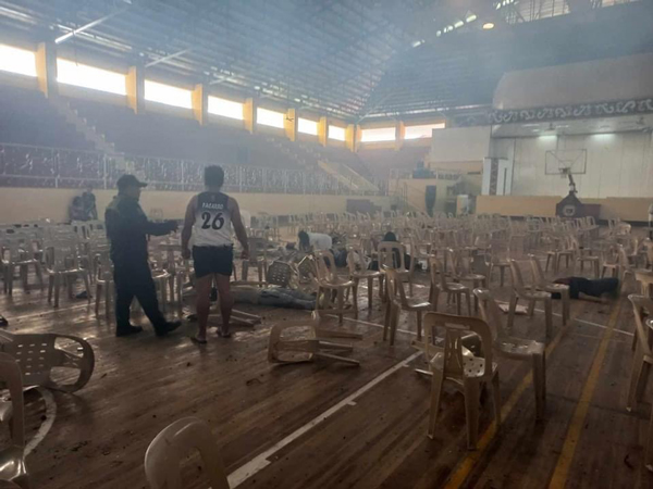 棉兰老国立大学体育馆发生爆炸后，椅子散落满地，有人倒地不起。