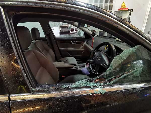 被歹徒双击夹击的轿车，左右两方的玻璃都被击破。