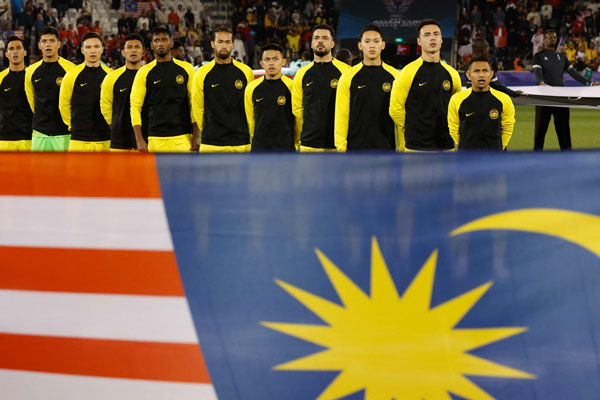 Malaysia's starting eleven stand up for the national anthem before the start of the Qatar 2023 AFC Asian Cup Group E football match between Bahrain and Malaysia at the Jassim bin Hamad Stadium in Doha on January 20, 2024. (Photo by KARIM JAAFAR / AFP)