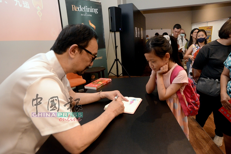 小女孩也不放过签名机会；一位小女孩拿着一本小册子找侯师傅签名。
