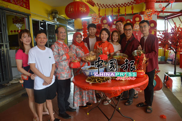 东姑祖布里夫妇（左3及4）展示数道马来美食，在场众人为陈家兄弟姐妹，前排穿红衣者为陈宝云。
