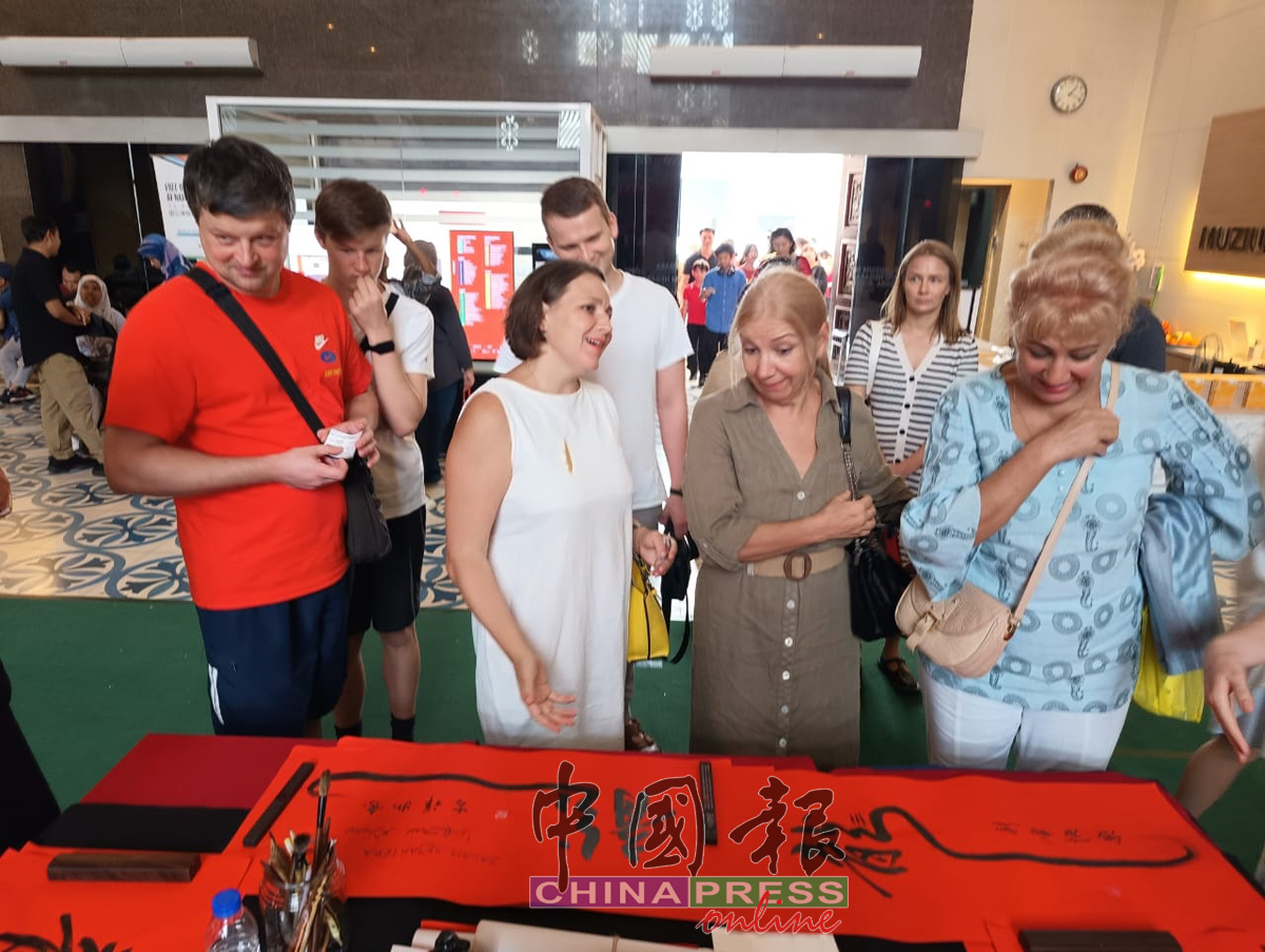 外国游客欣赏双语书法春联。