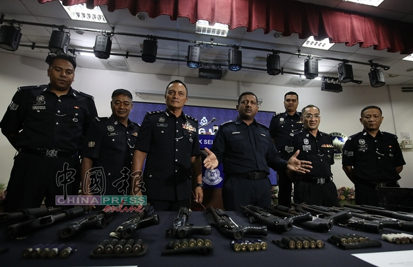 胡仙（右3）及建功下属，展示警方起获的11把泵式霰弹枪（pump gun）