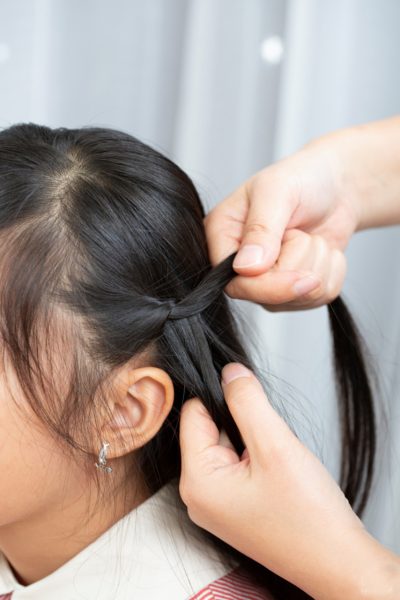 步骤4：固定原先头发，并抽取辫子底部加入二手辫中。