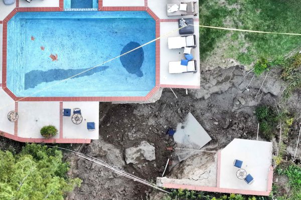 一棟房屋的地基遭沖刷，游泳池高懸在斷崖邊。（法新社）