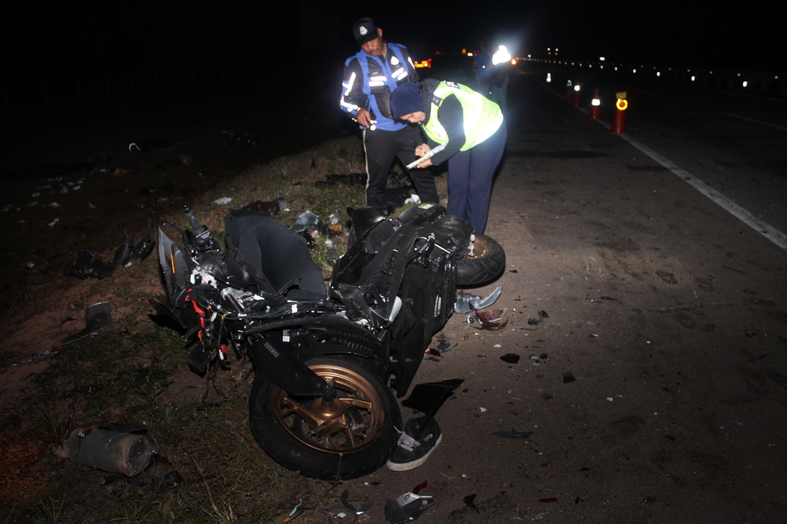 交警到场调查，并检查其中一辆被撞毁的摩哆。