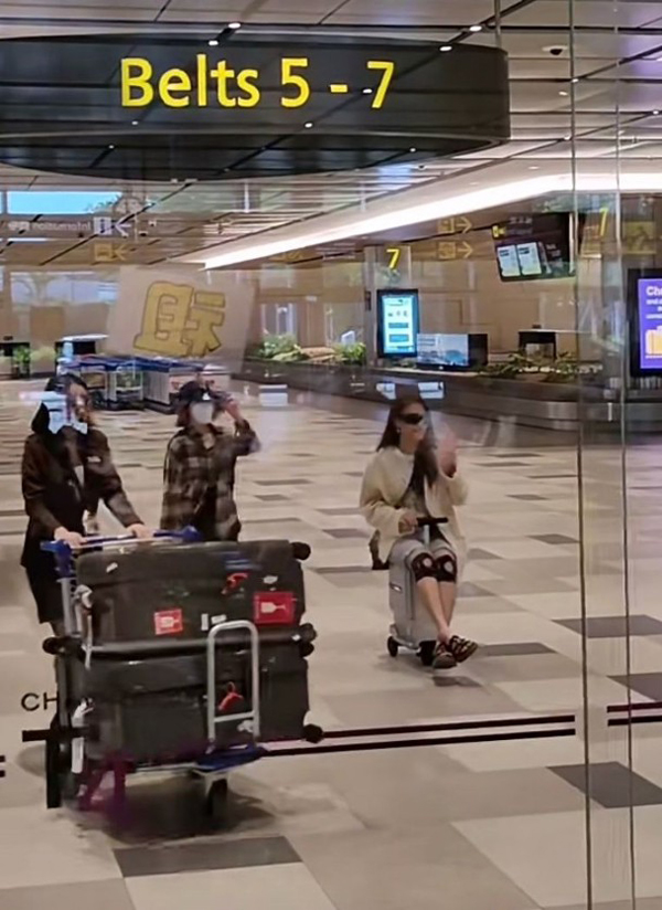 容祖儿负伤上阵，在机场坐着智能电动行李箱。