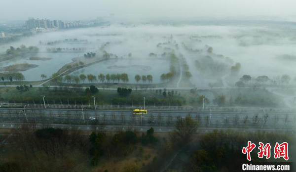 <b>春雾诗意画卷</b>－－　周五一场春雨过后，中国安徽池州薄雾氤氲，清新而美丽，薄如轻纱的晨雾，与城市、森林和湿地公园勾勒出一幅美丽的初春晨景图。从空中俯视大地，春色在雾中若隐若现，沉浸其中，仿佛置身于一个充满神秘与诗意的世界。（中新网）
