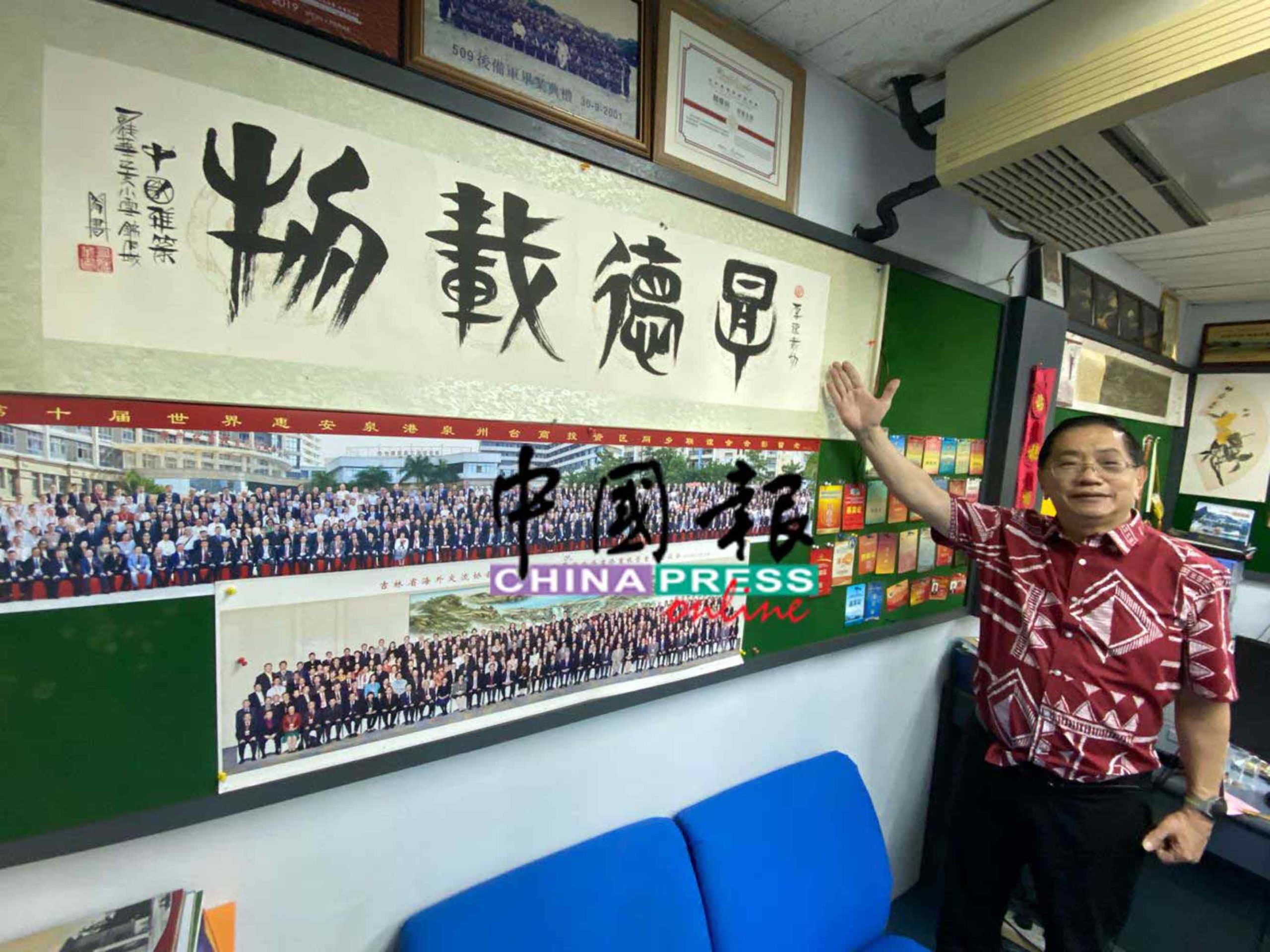 郑荣兴将中国带回的纪念品，张挂在办公室墙上，“厚德载物”四字是由书法大师所题。
