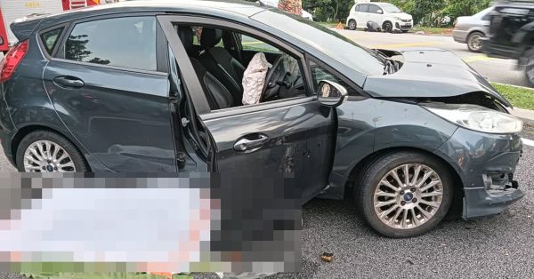 轿车与摩哆相撞后，骑士卧尸在司机座位的车门旁。