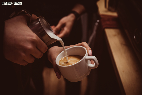 Barista makes flavored cappuccino, pours milk into coffee