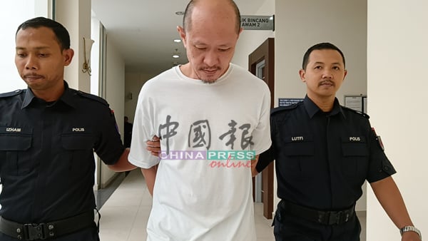 新加坡籍被告黄连志（中）判刑后，被庭警带离法庭押往监狱服刑。