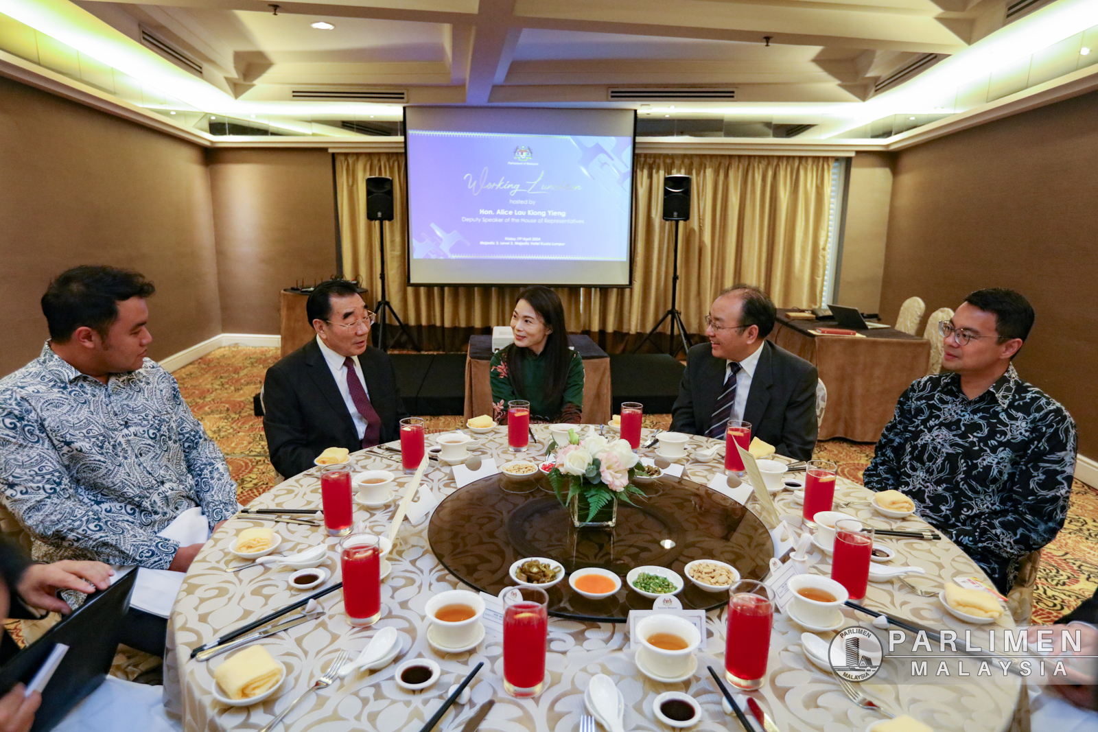 刘强燕（中）在餐桌上与张庆黎（左2）交流；右起为李健聪、欧阳玉靖和郭子毅。