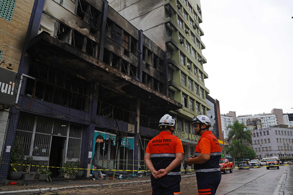 4月26日，消防人员在阿雷格里港市的火灾现场开展工作。这座三层建筑已经严重烧毁。