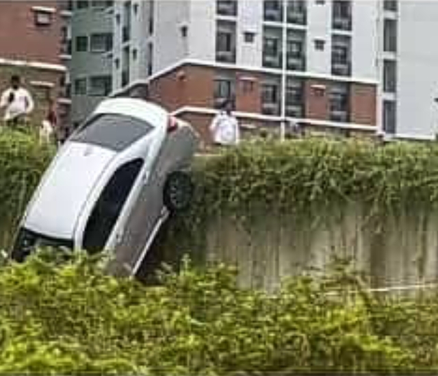 一辆轿车疑手刹没拉，滑下斜坡后车头径直砸落地面。