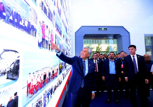 阿末扎希（左）在参观北方国际教育集团园区时，发现看板上出现他与其他MARA领袖的合照，而乐开怀。