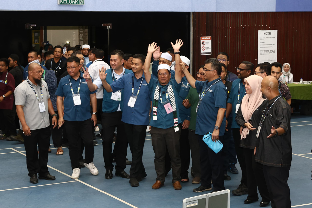 成功帮助国盟守土的阿比丁(左5),在国盟领袖和支持者陪同下,抵达爪夷多用途礼堂计票中心。