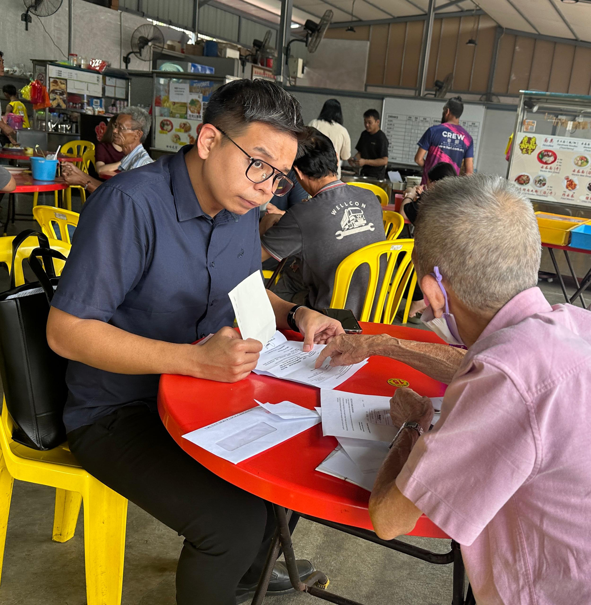 王俊伟在茶室协助一名长者处理无国籍问题。