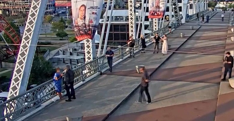 邦乔飞和途人合力将女子带回桥上大路位置。