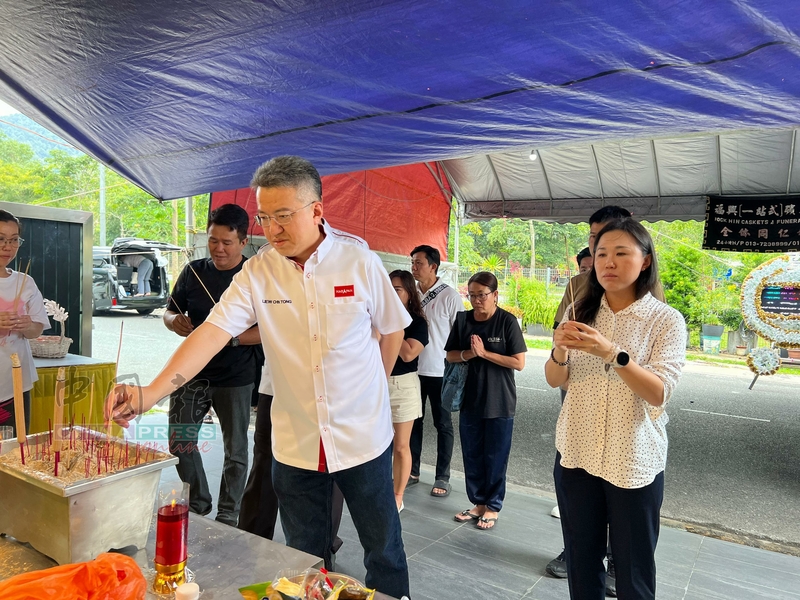 刘镇东（站者左起）及黄书琪，在灵堂上香。