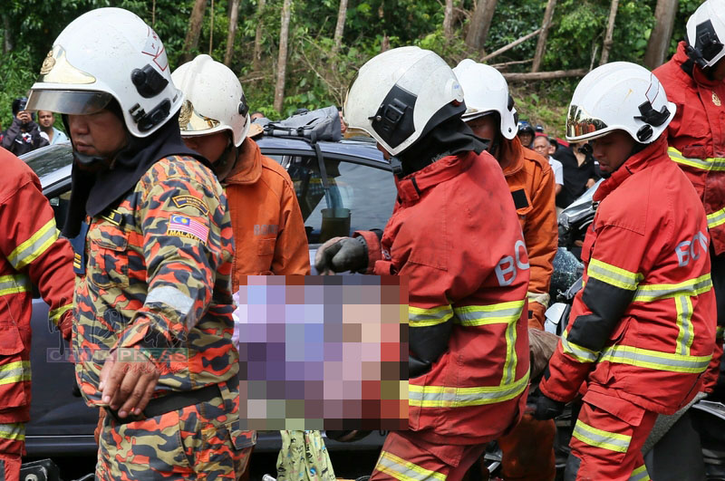 消拯员把死者遗体从车座上移出。
