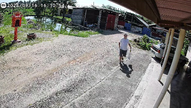 华裔地主拎着袋子走回住家。