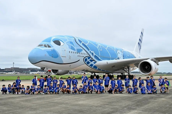 参与挑战的小学生在空巴A380前合照留影。