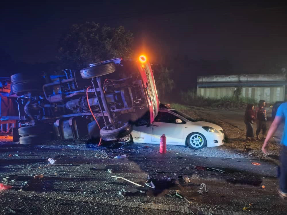 遭撞及尾部的拖格罗厘，也被撞至翻覆，压在前方泊在路旁的丰田轿车上。（警方提供）