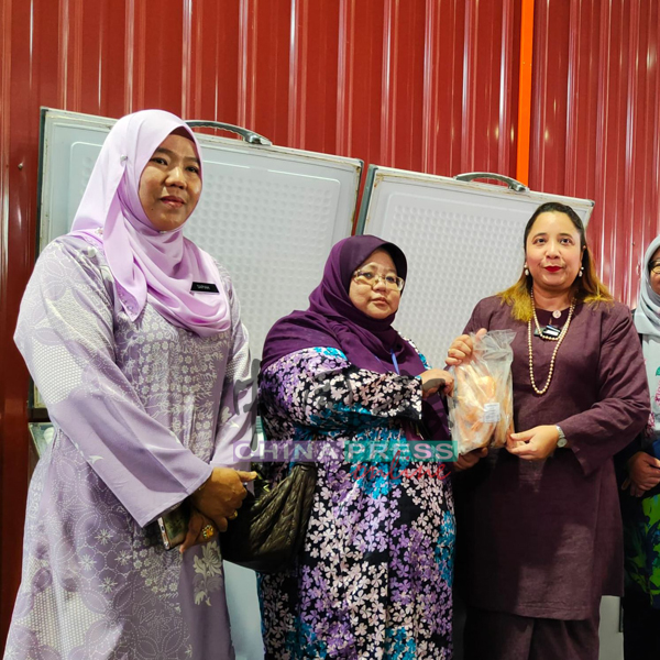 诺丽娜(右起)移交冷冻鸡予查丽雅,左为莎碧雅。