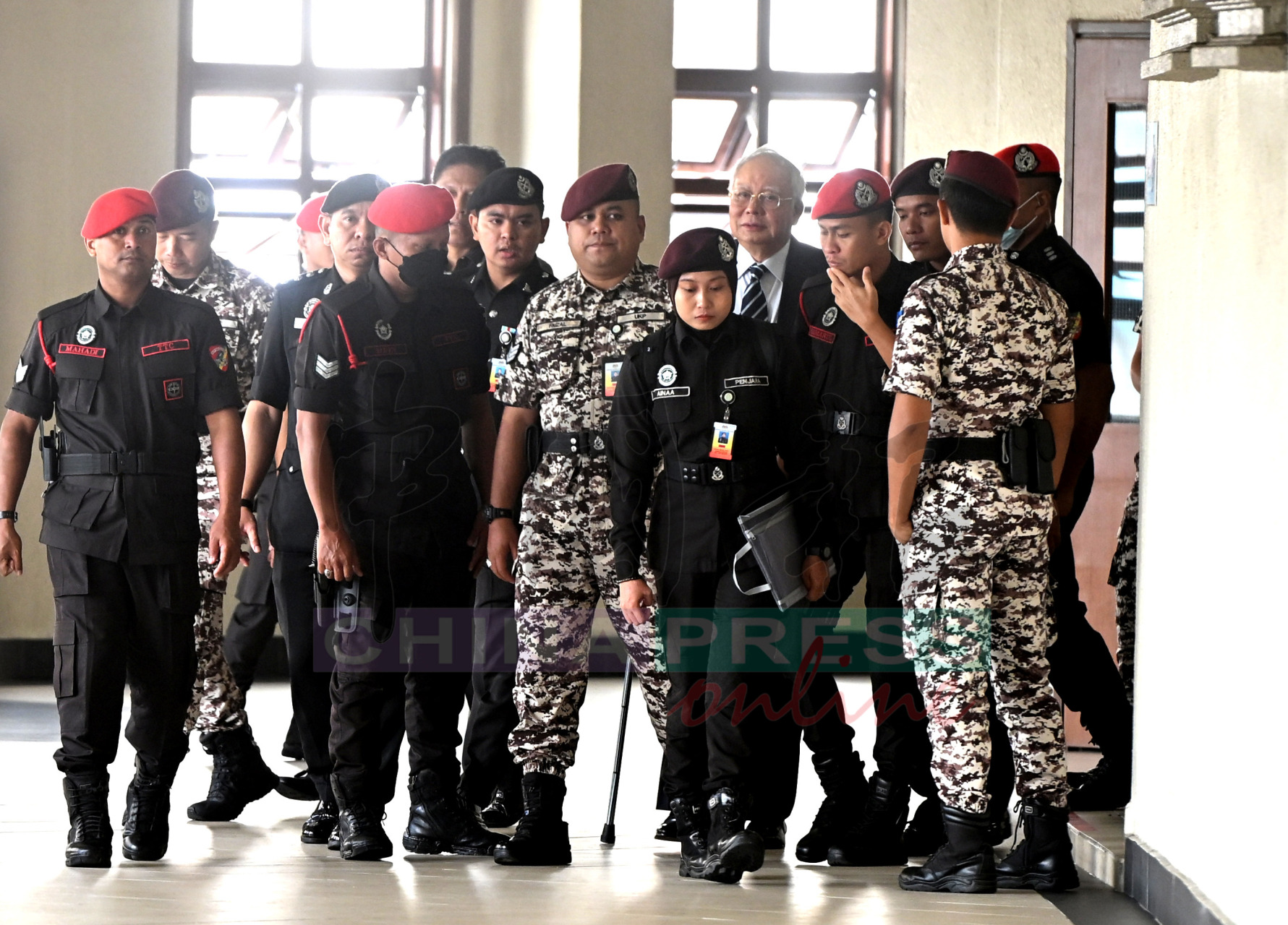 纳吉(中)拄拐杖,精神奕奕出庭自辩。