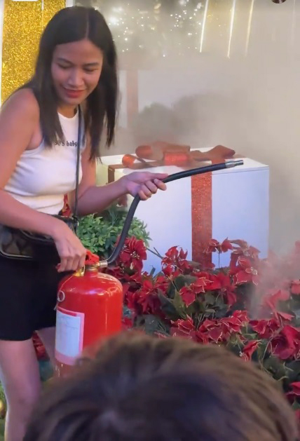 白衣女子拿出灭火器试图灭火。