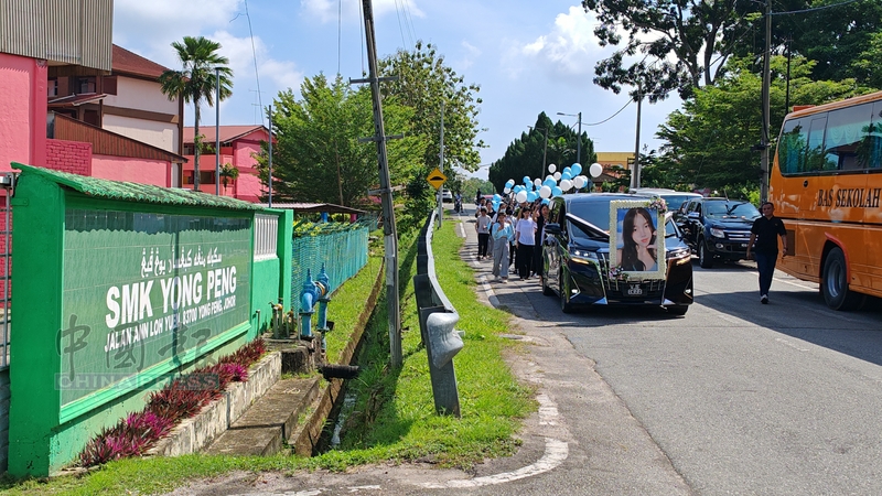 师生们手持蓝白色气球尾随灵车停在永平国中校门前，让沈惠怡向母校告别。