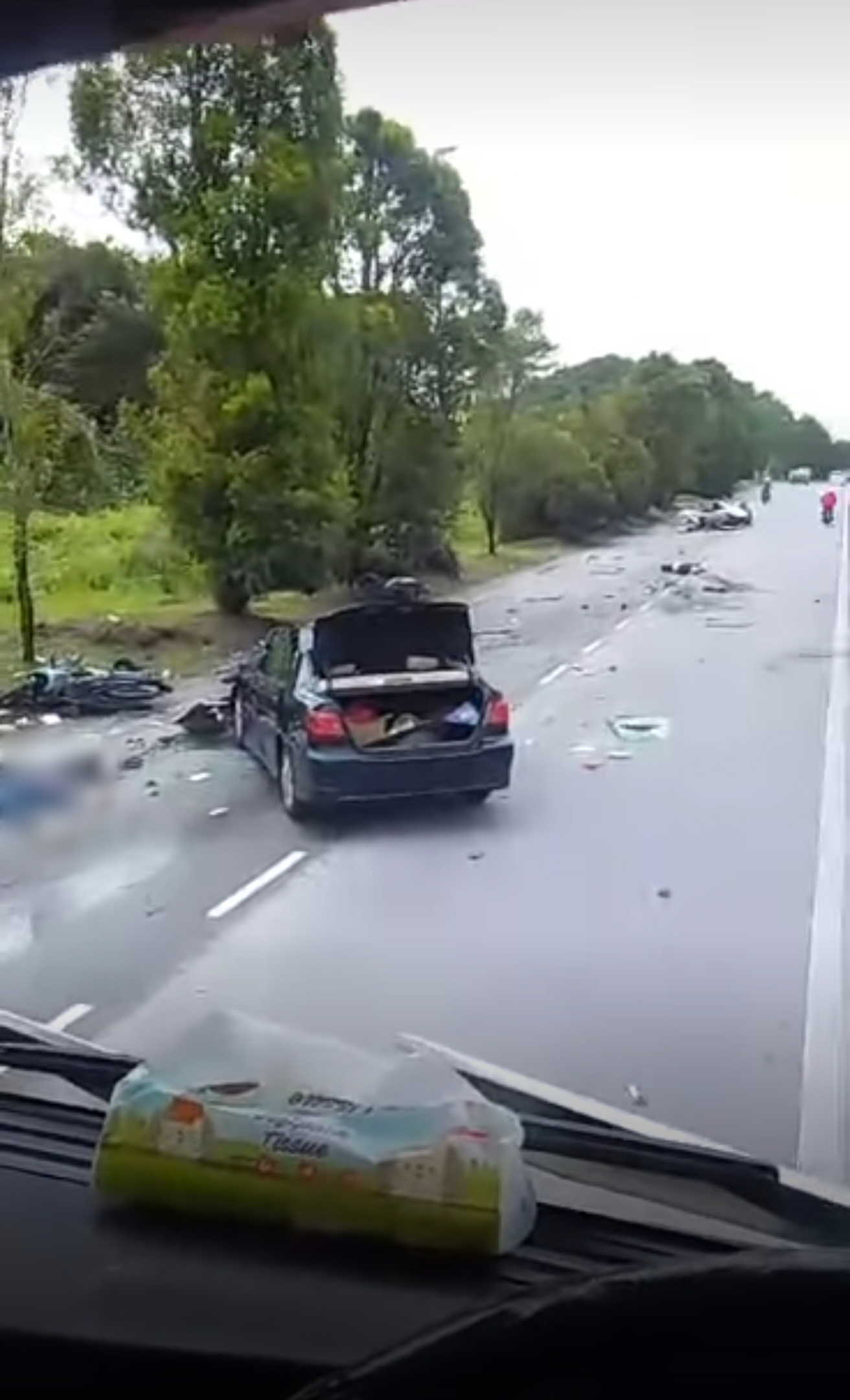 车祸现场一片狼藉，遍布轿车零件，至少3人失去意识的躺倒在马路上。