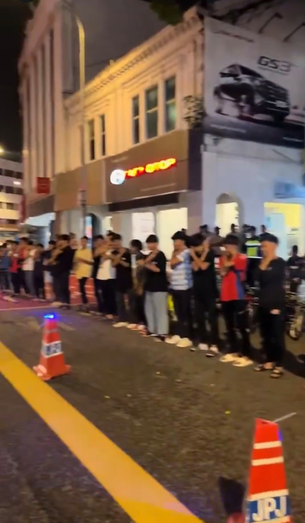 逾20名少年在警方的监督下，在大街上罚蹲。
