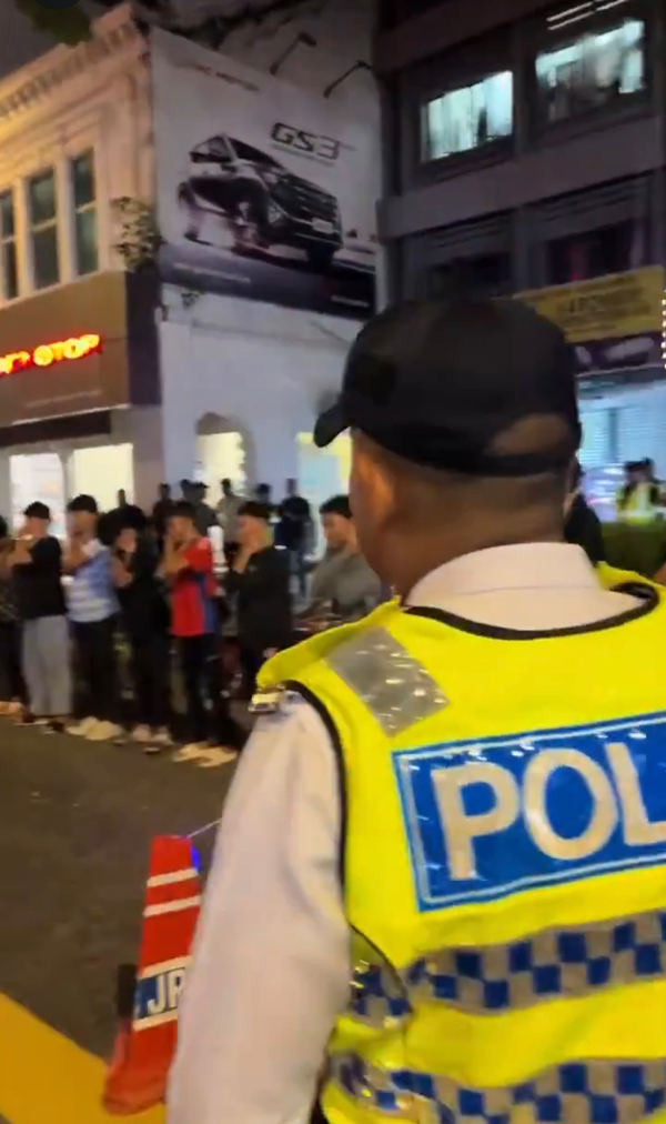 逾20名少年在警方的监督下，在大街上罚蹲。
