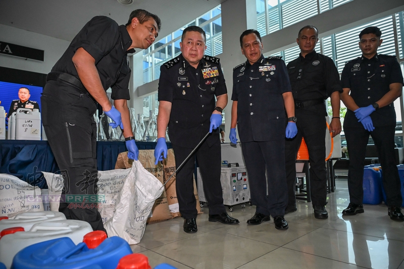 许国振（左2）展示袋子中的炼毒工具；左3为吉隆坡总警长拿督鲁斯迪。
