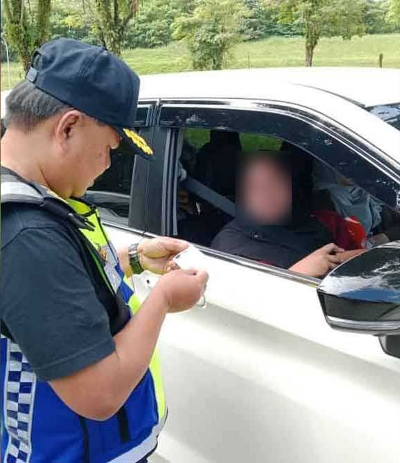 阿末卡玛鲁扎曼检查其中一名女司机的证件。