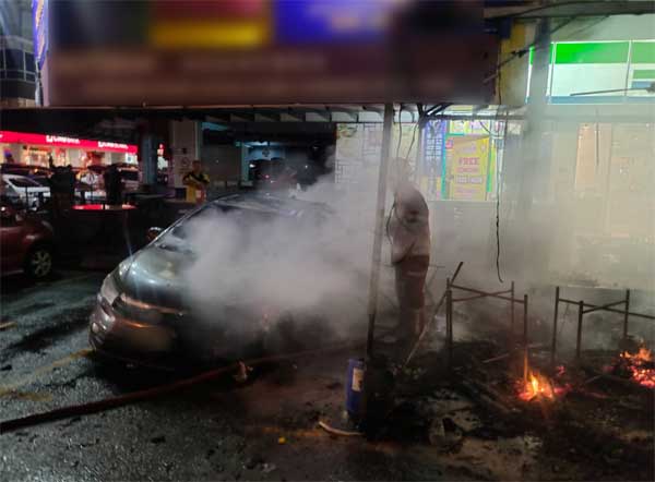 消拯员将波及轿车上的火势扑灭。