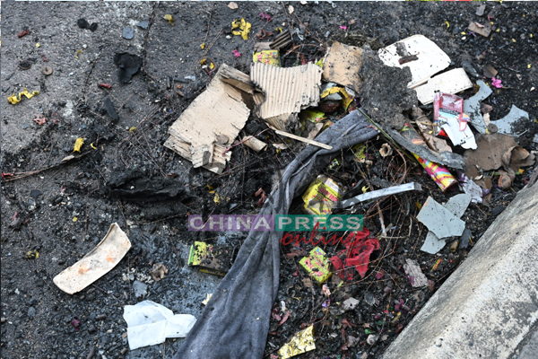 3辆已被烧得近乎报废的轿车仍停在现场，燃炸后的爆竹残骸、塑料和纸皮碎片在摊位帐篷里堆积成山。